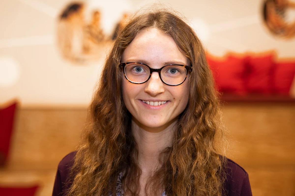 Eine junge Frau blickt in die Kamera.