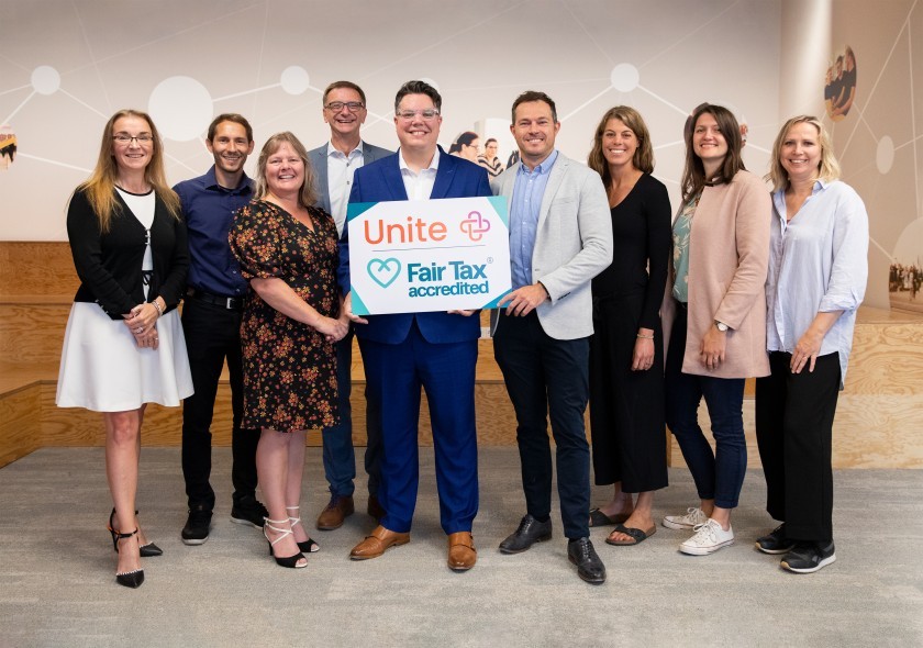 Unitees holding the sign for receiving the Fair Tax Mark