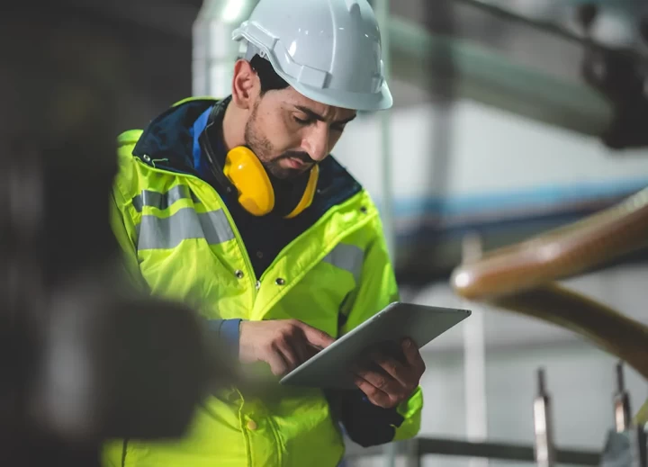 Mann in Arbeitsschutzkleidung mit Helm und Gehörschutz