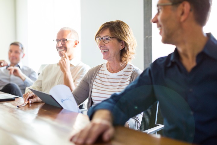 A group of HR professionals sit at a table discussing recruitment