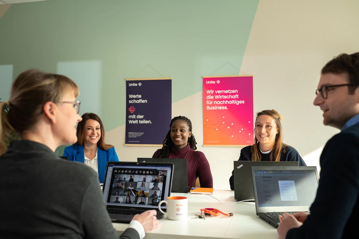 Unitees at work: sitting in an office with computers open.