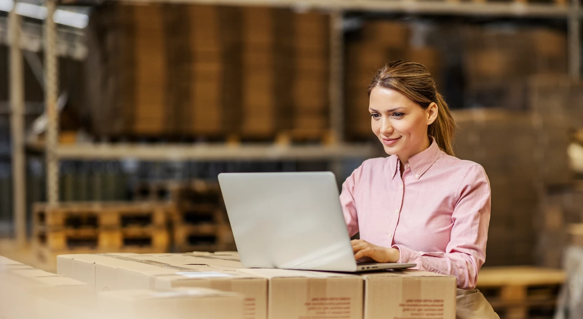 Smiling woman working on a laptop in a professional environment