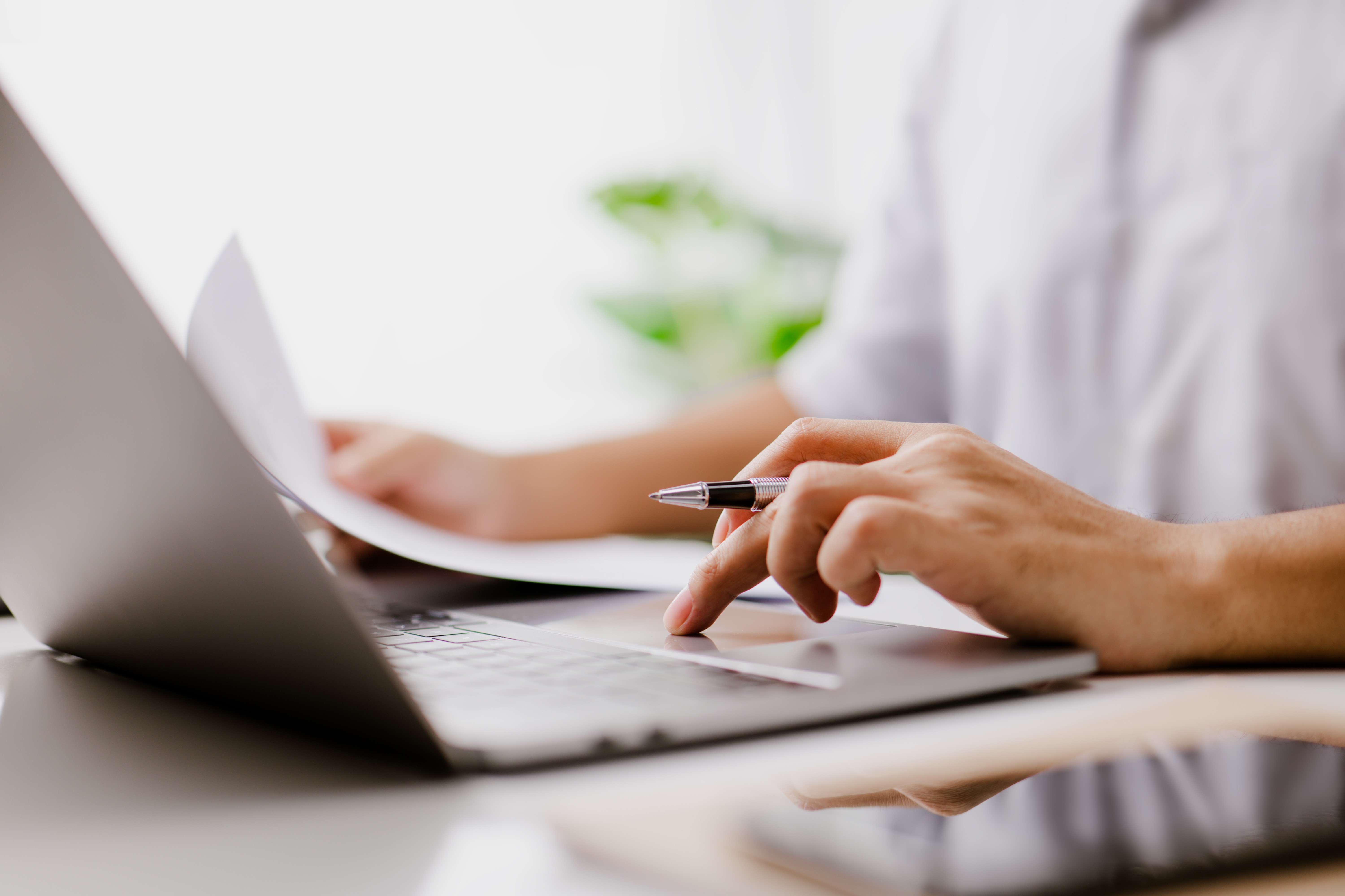 Un responsable achats navigue sur son ordinateur portable et consulte un document commercial.