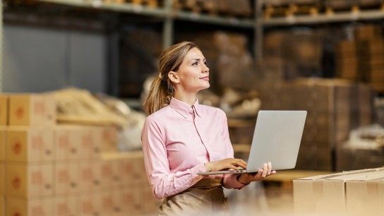 Warehouse supervisor with laptop ordering supplies