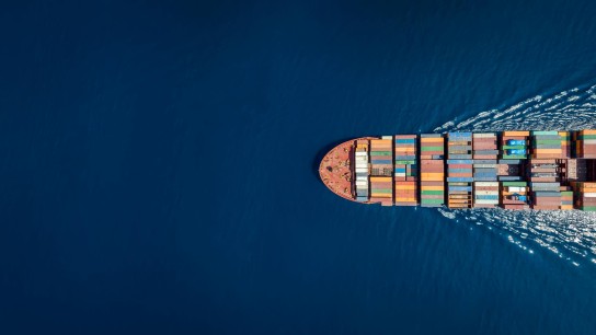 Un barco de carga surca el océano cargado de contenedores de transporte de mercancías 