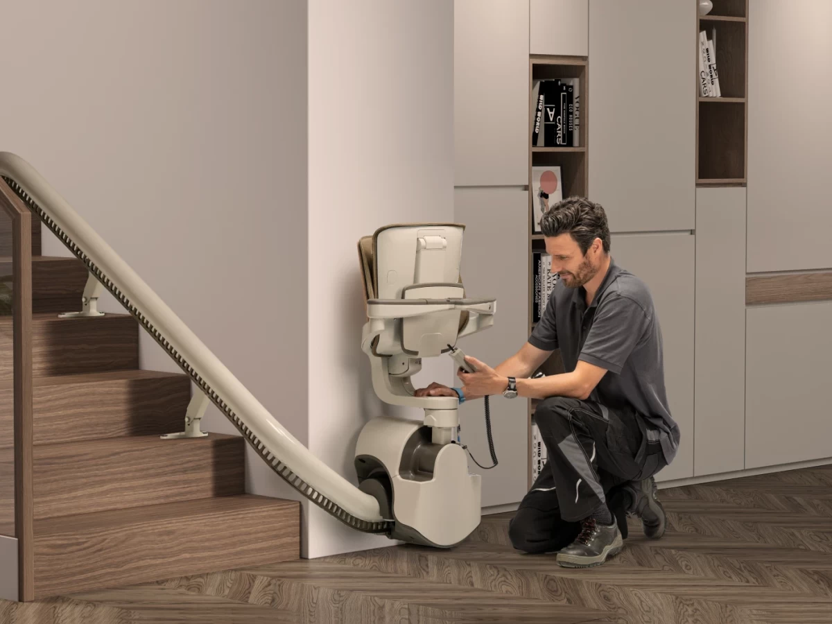 Un installateur contrôle un monte-escalier chez un particulier