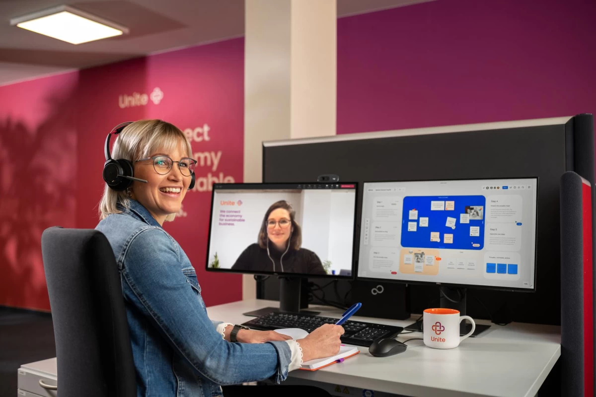 Eine Frau sitzt an einem Schreibtisch und dreht sich um zum Fotografen des Bildes