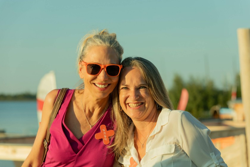 Two smiling women at the summer party in golden hour light