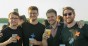 Vier junge Männer mit Getränken in der Hand auf dem Unite Sommerfest