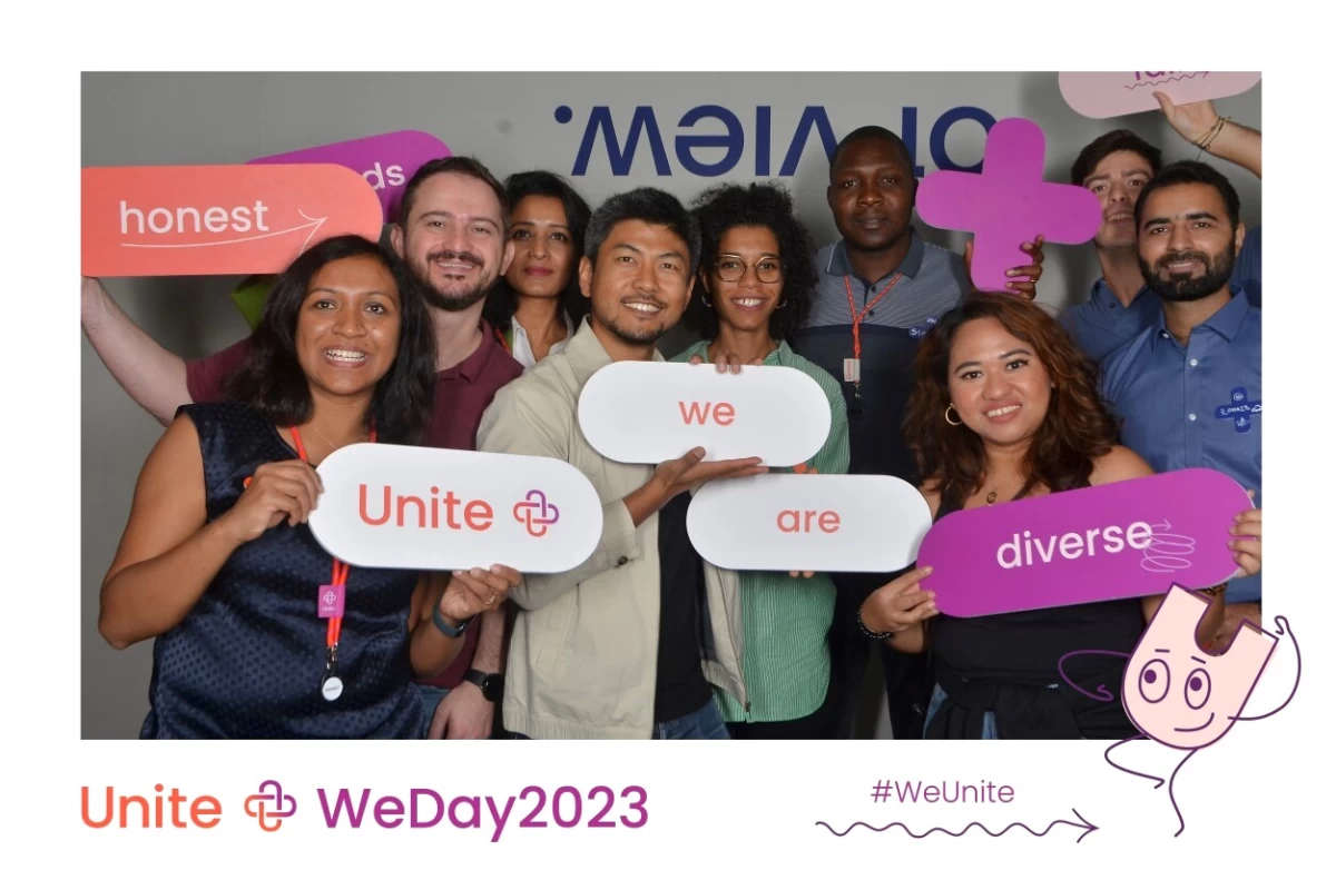 Nine employees from DE&I resource group holding signs for a photobooth