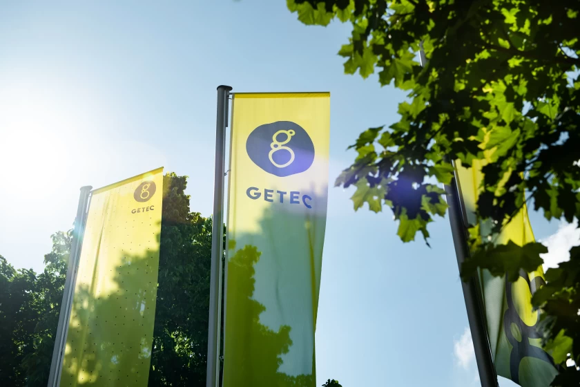 flags from Getec next to trees in the sky