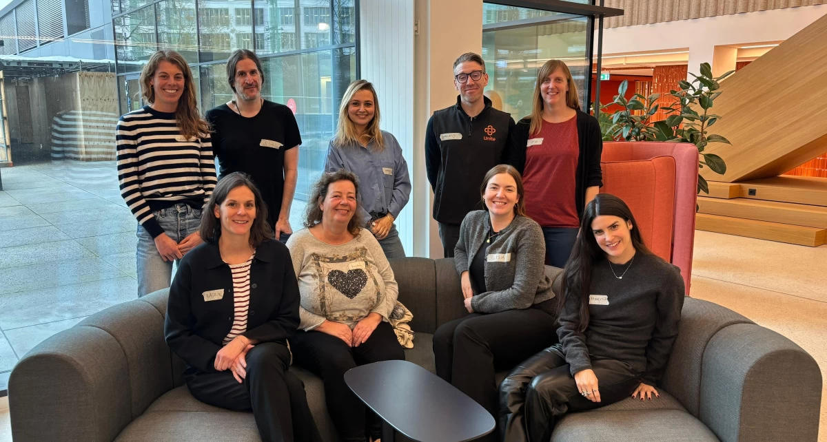 Gruppenbild aus Männern und Frauen in einem Besprechungsraum