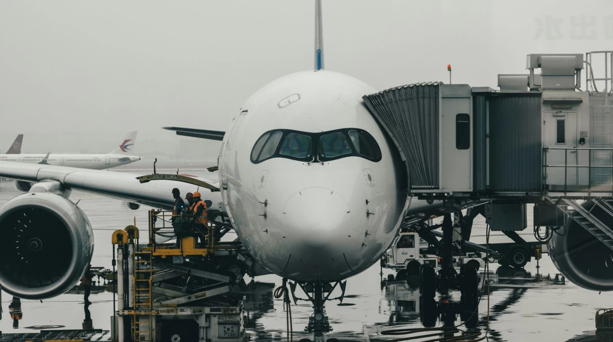 An airplane docked at the finger and the ground crew who inspected it