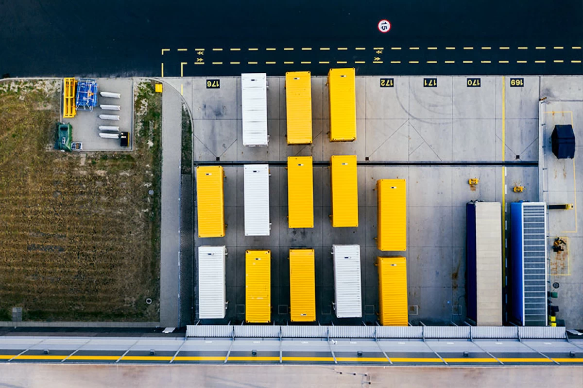 Vue du ciel de treize conteneurs blanc et jaune sur un parc de stockage
